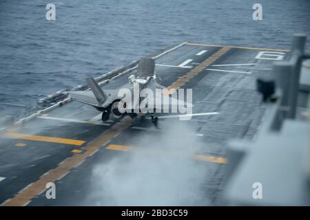 Un combattente furtivo del corpo marino statunitense F-35B Lightning II, assegnato alla 31a Marine Expeditionary Unit, esegue un atterraggio verticale sul ponte di volo della nave d'assalto anfibio americana di classe Flagship USS America durante le operazioni di routine il 4 aprile 2020 nel Mare delle Filippine. Foto Stock