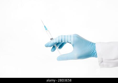 Mano nella siringa con guanti blu isolata su sfondo bianco Foto Stock
