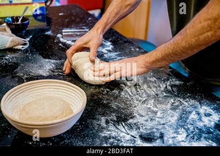 Uomo impastare pasta di pane in cucina Foto Stock