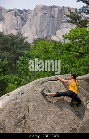 Scalatore femmina bouldering al parco nazionale di Seroksan in Corea del Sud Foto Stock