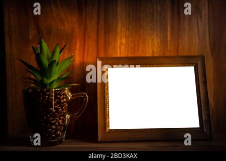 Isolare la cornice dell'immagine sul tavolo e il chicco di caffè nel vetro. Foto Stock