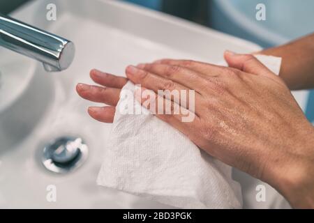 Lavando le mani gradini per igiene personale COVID-19 prevenire l'asciugatura delle mani dopo il lavaggio a mano con un tovagliolo di carta. Infezione da coronavirus pulizia preventiva. Foto Stock