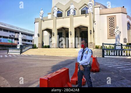Antipolo City, Filippine - 4 aprile 2020: Guardia di sicurezza di fronte alla chiusa e vuota Cattedrale di Antipolo durante la chiusura a causa del Covid 19 Foto Stock
