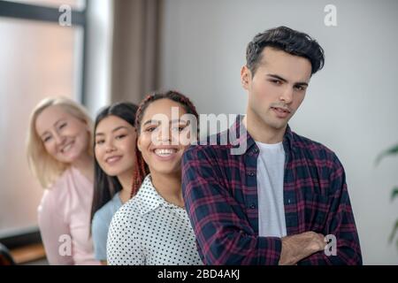 Gruppo di persone che si alzano vicino e sorridono Foto Stock