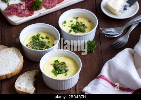 Colazione con omelette, salsiccia, pane e burro su sfondo scuro. Foto Stock