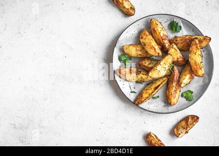 Zeppe di patate al forno con formaggio ed erbe - verdure biologiche fatte in casa vegetariane zeppe di patate snack pasto, vista dall'alto, spazio per le copie. Foto Stock