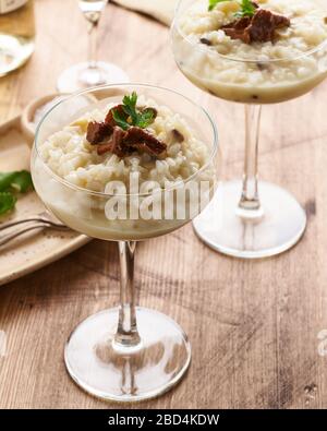 Risotto con funghi in bicchiere di vino. Servizio inusuale non convenzionale. Vista laterale, verticale Foto Stock