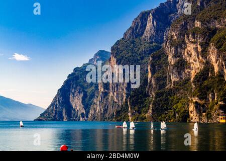 Riva del Garda, Trentino Alto Adige / Italia - Settembre 24 2017: Piccoli yacht navigano sul lago sullo sfondo delle montagne. Foto Stock