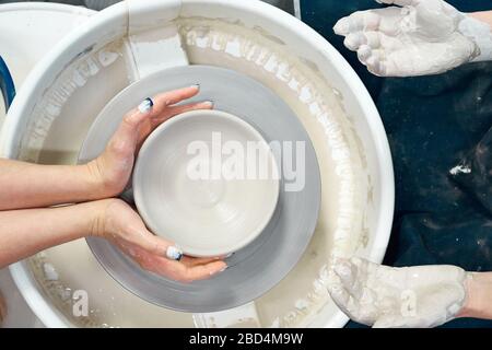 Donna che fa ceramica ceramica su ruota, mani primo piano. Concetto per donna in freelance Foto Stock