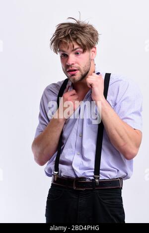 Uomo con capelli cadi e discreti isolato su sfondo bianco. Nerd o bookworm che indossa i supenders. Uomo o studente con setole e faccia confusa in camicia a quadri. Sindrome di Wisehead e concetto di stile nerdish Foto Stock