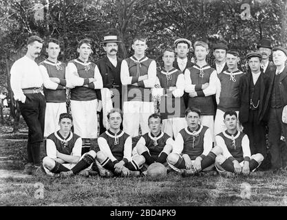 Una prima fotografia in bianco e nero edoardiano d'epoca, scattata in Inghilterra, che mostra i membri di una squadra di football dei ragazzi, o di calcio, insieme ai loro allenatori, allenatori, manager, ecc. Foto Stock
