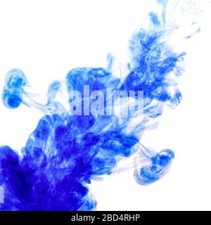 Inchiostro blu iniettato in acqua dalla siringa, mescolando colore con acqua creando forme astratte, Foto Stock