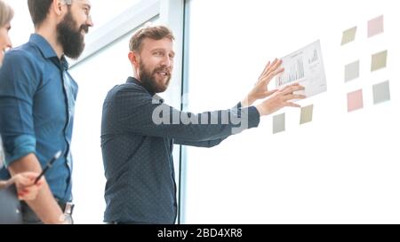 Il team Aziende a discutere di pianificazioni finanziarie in piedi in ufficio Foto Stock