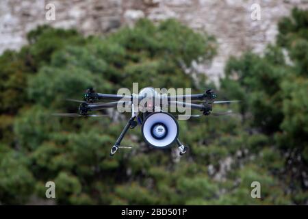 Salonicco, Grecia - 6 aprile 2020: Drone con messaggio registrato informa i cittadini di Salonicco di rimanere a casa per essere protetti dal coronavirus Foto Stock