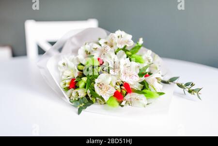 Bouquet di fiori di alstroemeria bianchi in giace su un tavolo bianco rotondo Foto Stock