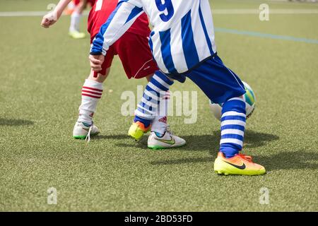 ragazzi che giocano a calcio su erba sintetica Foto Stock