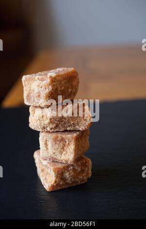 Quattro pezzi di fudge accatastati insieme su uno sfondo nero Foto Stock