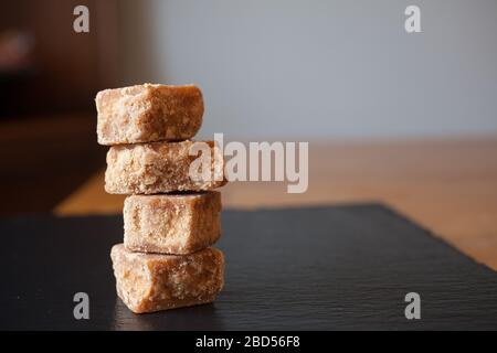 4 pezzi di fudge accatastati insieme su un pezzo di ardesia nera Foto Stock