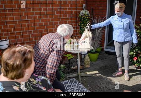 Amburgo, Germania. 7 aprile 2020. Cornelia Poletto, cuoco televisivo, distribuisce porzioni di cibo cucinato in casa di fronte alla casa di riposo AWO a Lenzstraße. Poletto cucina regolarmente il cibo per gli anziani bisognosi e lo consegna lui stesso. Credit: Axel Heimken/dpa/Alamy Live News Foto Stock