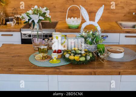 Bella primavera Pasqua bancone cucina. Fiori e uova decorative. Vaso di gigli sul banco. Foto Stock