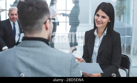 donna d'affari che discute qualcosa con un collega prima di un incontro d'affari Foto Stock