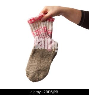 la mano femminile tiene un paio di calzini di lana a maglia, abiti caldi, l'oggetto è isolato su uno sfondo bianco Foto Stock