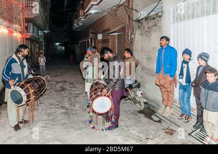 Punjabi dhol giocatori in strada, Medhi processione alla casa dello sposo, Jhelum, Punjab, Pakistan Foto Stock