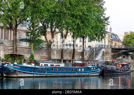 Barche sul fiume ormeggiate lungo la Senna vicino a Pont des Arts, Parigi, Francia Foto Stock