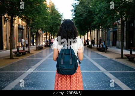 Vista posteriore di una donna turistica con zaino pronto a visitare la città. Concetto di viaggio da solo Foto Stock