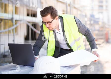 Architetto/ingegnere civile giovane e attraente al lavoro in un cantiere Foto Stock