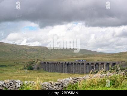 Ribblehead, North Yorkshire, UK, 08/28/2015 - Veiw di un treno passeggeri di due auto che attraversa Ribblehead Viaduct nelle Yorkshire Dales. Foto Stock