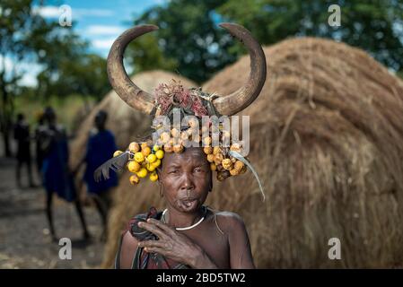 Con il suo piatto di labbra di argilla rimosso donna con frutta secca e corno di bestiame, tribù Mursi o gruppo etnico, Olikoru Village, Jenka, Etiopia. Foto Stock