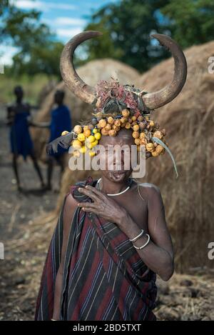 Con il suo piatto di labbra di argilla rimosso donna con frutta secca e corno di bestiame, tribù Mursi o gruppo etnico, Olikoru Village, Jenka, Etiopia. Foto Stock