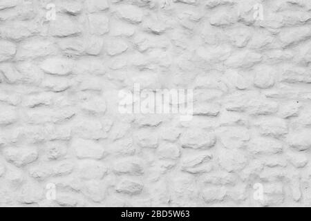 Vista frontale della parete in pietra dipinta di bianco antico, sfondo senza cuciture con texture fotografiche Foto Stock