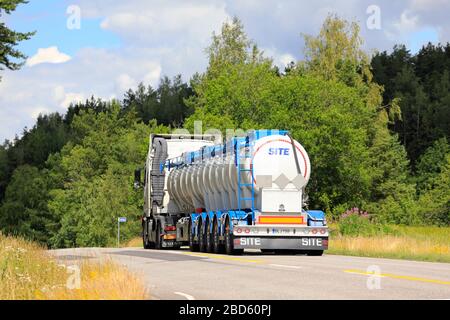 Veicolo bianco che traina un semirimorchio con serbatoio a 5 assali su autostrada estiva, vista posteriore. Salo, Finlandia. Luglio 6, 2019. Foto Stock