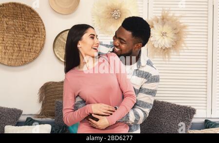 Marito afro-americano e moglie europea sorridenti l'uno all'altro Foto Stock