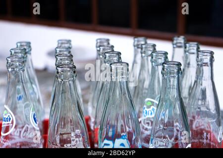 Scatola con bottiglie di vetro vuote di Coca Cola, e altre bevande. Bottiglie in vetro per il riciclaggio. Foto Stock