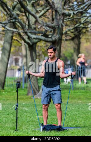 Londra, Regno Unito. 7 aprile 2020. Un formatore registra un video di esercitazione su Clapham Common - il "blocco" continua per l'epidemia di Coronavirus (Covid 19) a Londra. Credit: Guy Bell/Alamy Live News Foto Stock