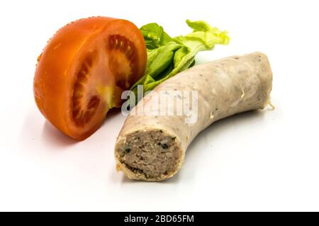 Un pezzo di salsiccia bianca su fondo bianco con mezzo pomodoro e una foglia di insalata Foto Stock