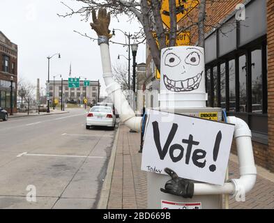 Racine, Wisconsin, Stati Uniti. 7 Aprile 2020. Le elezioni presidenziali primarie e statali del Wisconsin procedono martedì 7 aprile 2020 dopo una giornata di dispute legali. La città di Racine, Wisconsin, aveva solo la registrazione e il voto degli elettori sul marciapiede. Un appaltatore di fornitura di impianti idraulici ha messo un'esposizione whimsical che invita la gente a votare davanti al deposito. Il municipio è sullo sfondo. Credit: Mark Hertzberg/ZUMA Wire/Alamy Live News Foto Stock