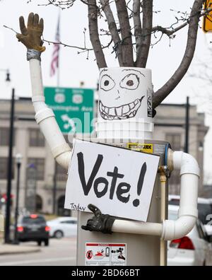 Racine, Wisconsin, Stati Uniti. 7 Aprile 2020. Le elezioni presidenziali primarie e statali del Wisconsin procedono martedì 7 aprile 2020 dopo una giornata di dispute legali. La città di Racine, Wisconsin, aveva solo la registrazione e il voto degli elettori sul marciapiede. Un appaltatore di fornitura di impianti idraulici ha messo un'esposizione whimsical che invita la gente a votare davanti al deposito. Il municipio è sullo sfondo. Credit: Mark Hertzberg/ZUMA Wire/Alamy Live News Foto Stock