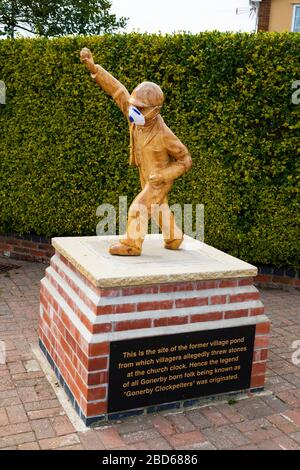 Statua "Clockpelter" con maschera medica durante la pandemia del virus Corona Covid-19. Great Gonerby, Grantham, Lincolnshire, Inghilterra. Aprile 2020 Foto Stock