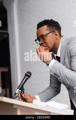 nervoso african american speaker mordere unghie durante la conferenza d'affari in ufficio Foto Stock