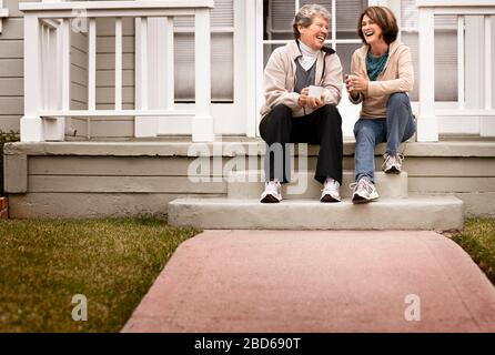 Una madre e figlia di recupero in un caffè sulla parte anteriore stoop. Foto Stock