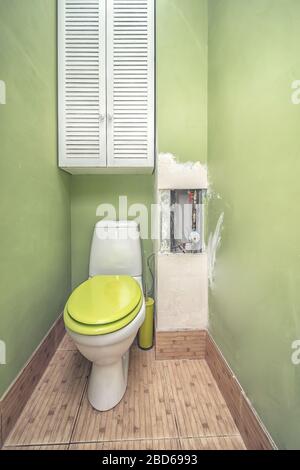 WC nel bagno. Servizi igienici con pareti dipinte di verde per lavori di ristrutturazione Foto Stock