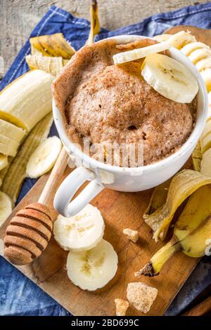 Torta di pane di Banana porzionato in piccole tazze. Facile dolce cottura idea, con banane fresche, noci, miele e spezie su rustico sfondo in legno copia Spac Foto Stock