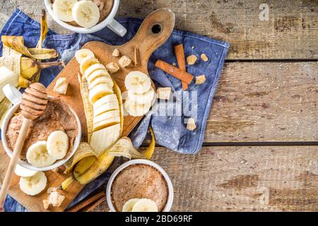 Torta di pane di Banana porzionato in piccole tazze. Facile dolce cottura idea, con banane fresche, noci, miele e spezie su rustico sfondo in legno copia Spac Foto Stock