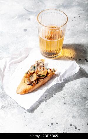 Bruschette o tapas con gustosa salsa di funghi su sfondo grigio cemento. Antipasto italiano aperto toast sandwich per party estate picnic Foto Stock