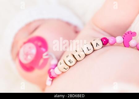 Bambina chiamata Leila Sleeping and weing a Wooden Pacifier Chain Foto Stock