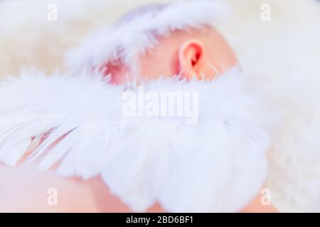 Il bambino dorme tranquillamente mentre indossa le ali dell'angelo e Halo Foto Stock
